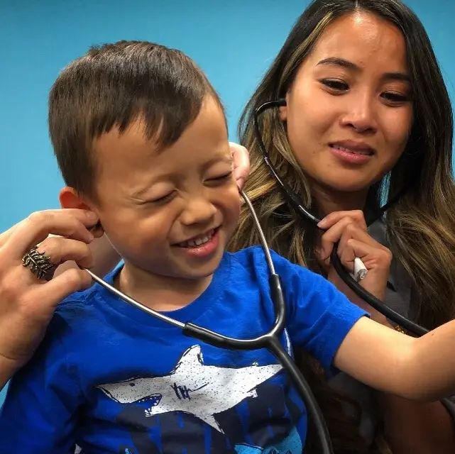 Woman works with young boy smiling