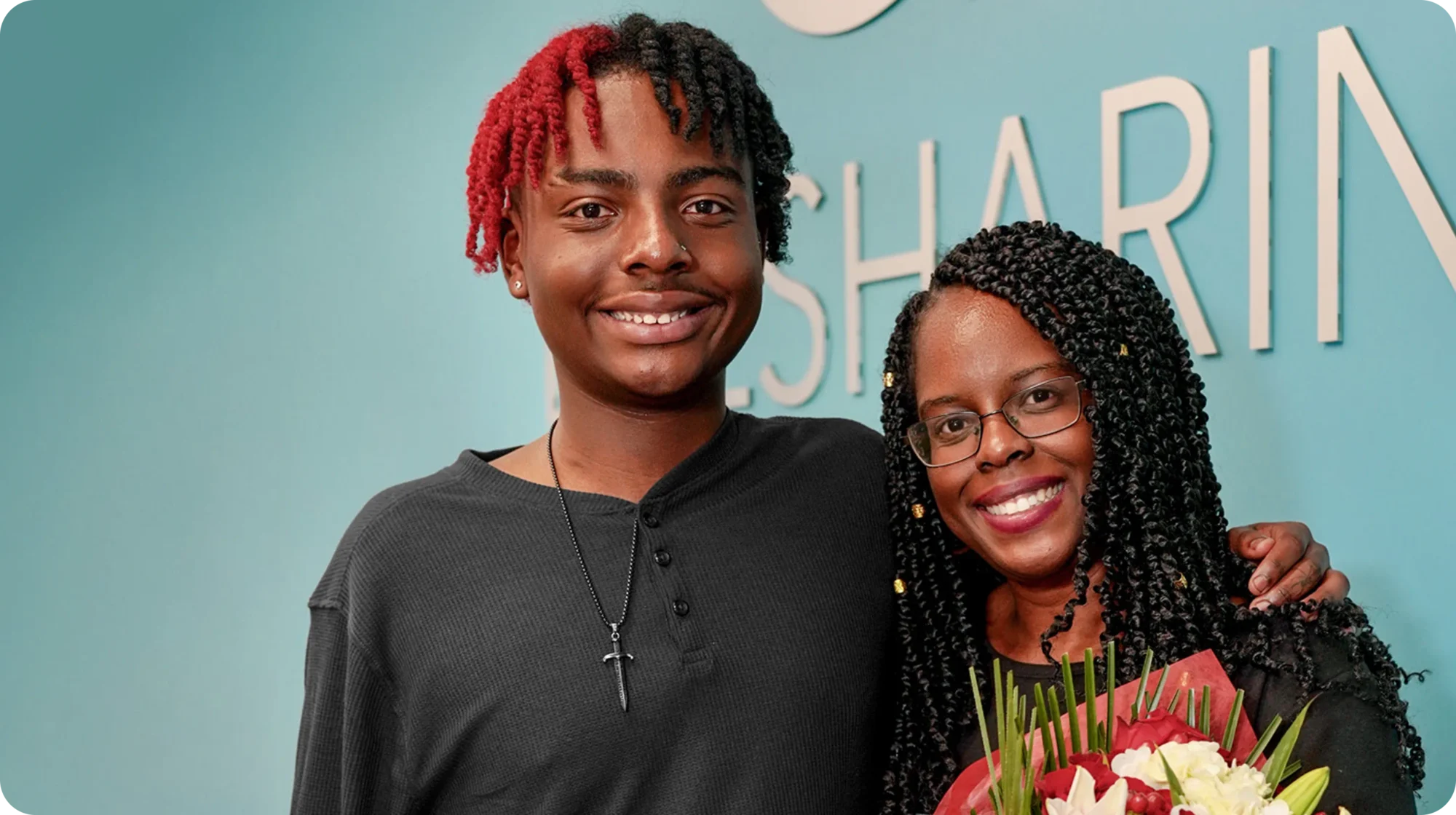 A young man stands with his mother